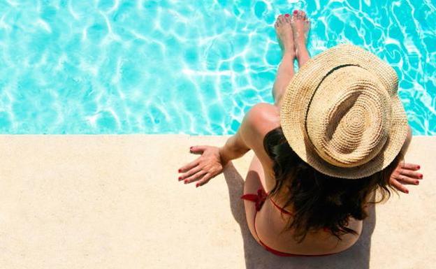 Woman sunbathing in a swimming pool. 