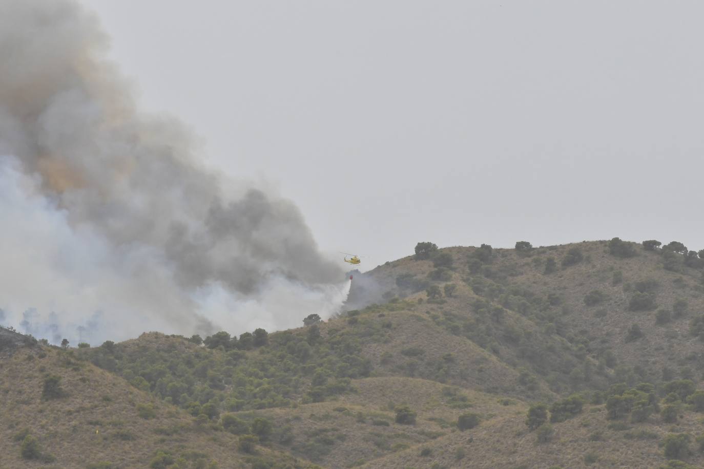 Image of a helicopter suffocating the Jumilla fire. 