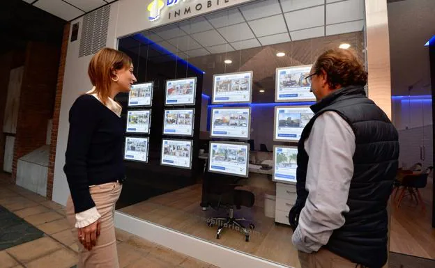 Two people contemplate the offer of a real estate agency in Murcia, in a file photo.
