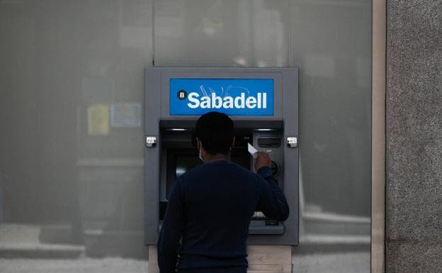 A man withdrawing money at an ATM, in a file image. 