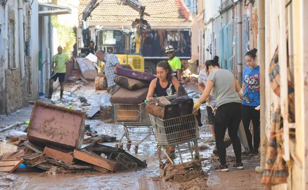 Residents of Javalí Viejo remove belongings from their houses after the floods. 