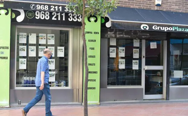 A man passes in front of a real estate agency in Murcia. 