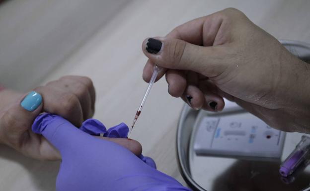 A health worker performs a test to detect hepatitis, in a file image.