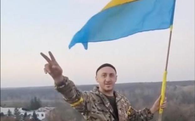 A Ukrainian soldier waves his nation's flag in the newly liberated Kalynivske, city of Kherson. 