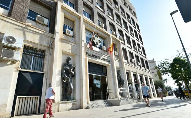 Citizens walk in front of the headquarters of the Provincial Court, in Murcia. 