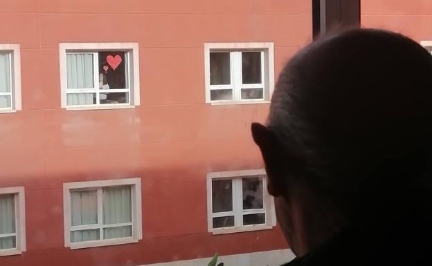 Un padre con demencia y su hija con síndrome de Down, conectados a través de la ventana por un corazón