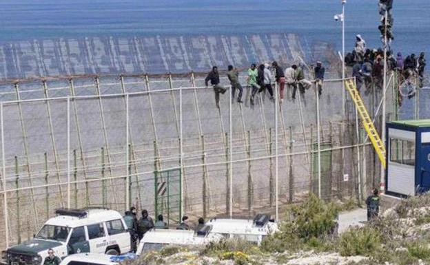 Immigrants perched on the fence of Melilla, in a file image.