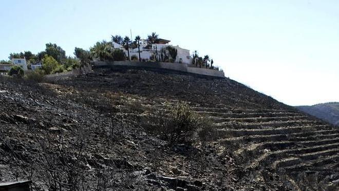 Los medios de extinción refrescan la zona que quedó arrasada por el fuego en Xàbia