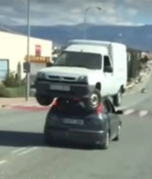 Pillan al conductor de un turismo transportando una furgoneta averiada en su techo