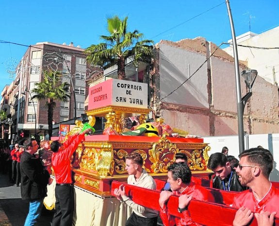 Costaleros con comida al hombro